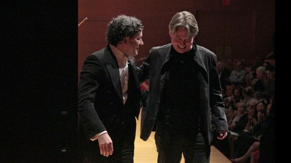 Gustavo Dudamel, left, and Esa-Pekka Salonen leave the stage Thursday after the Los Angeles Philharmonic played Salonen's "Helix" at Walt Disney Concert Hall.