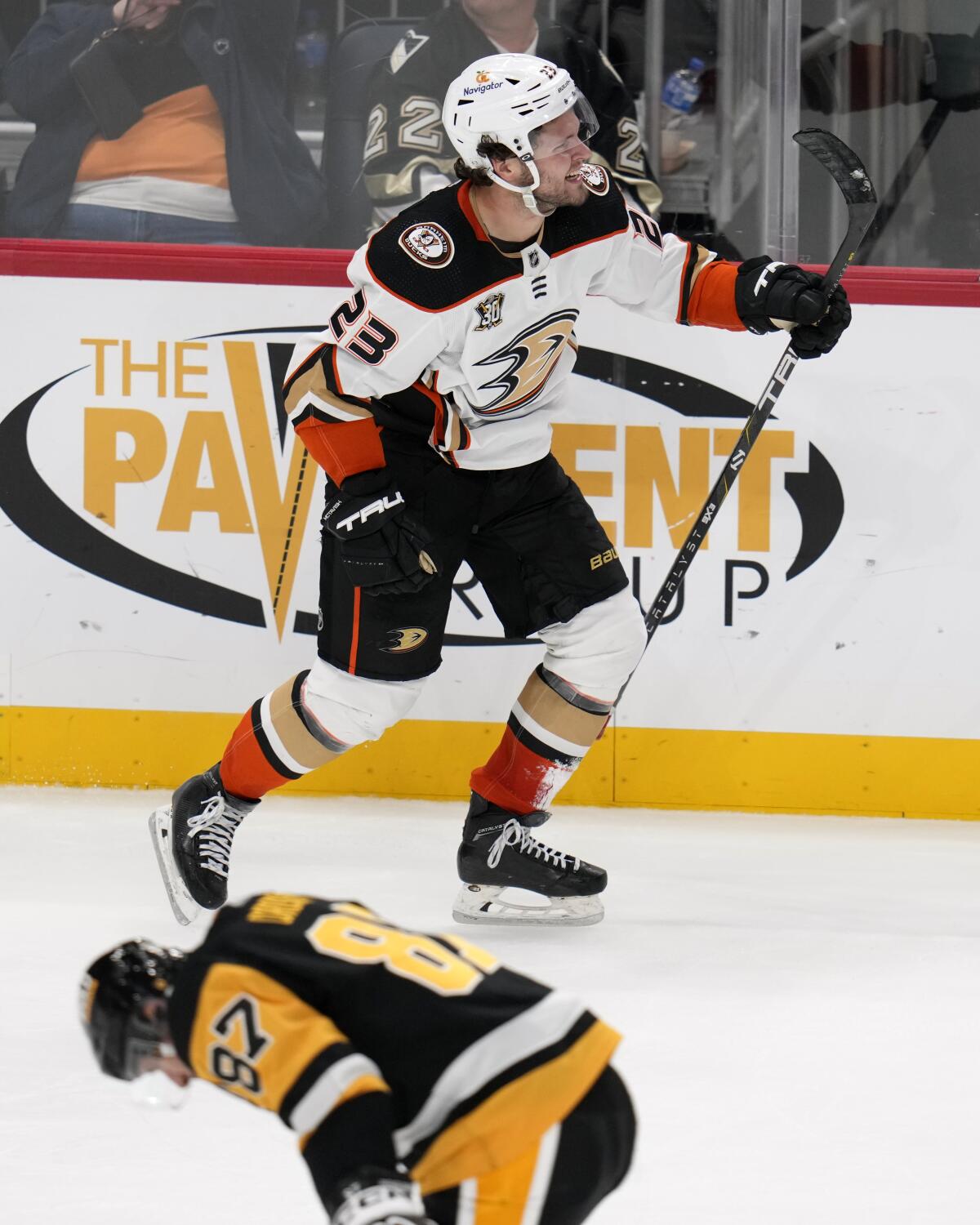 Ducks forward Mason McTavish skates past Pittsburgh Penguins star Sidney Crosby.