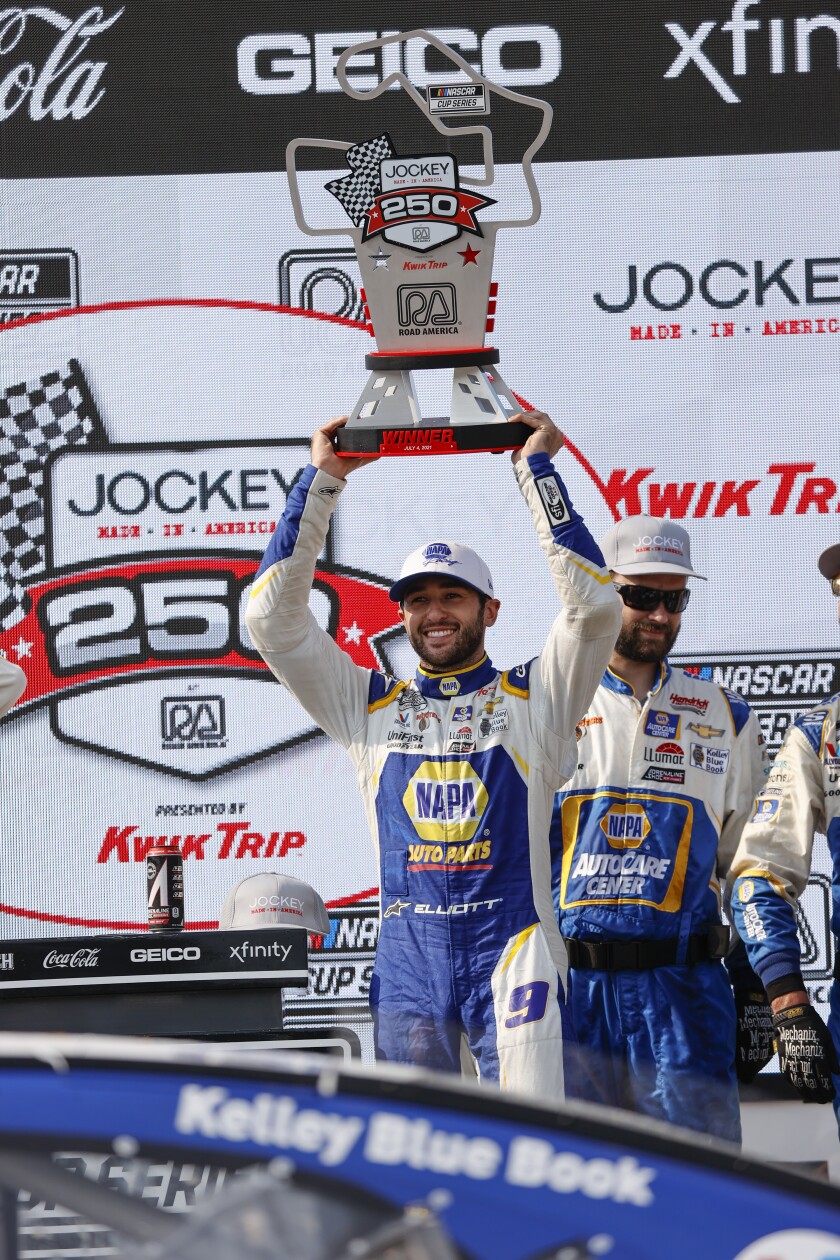 Chase Elliott (9) holds up his trophy after winning a NASCAR Cup Series auto race Sunday, July 4, 2021, at Road America in Elkhart Lake, Wis. (AP Photo/Jeffrey Phelps)