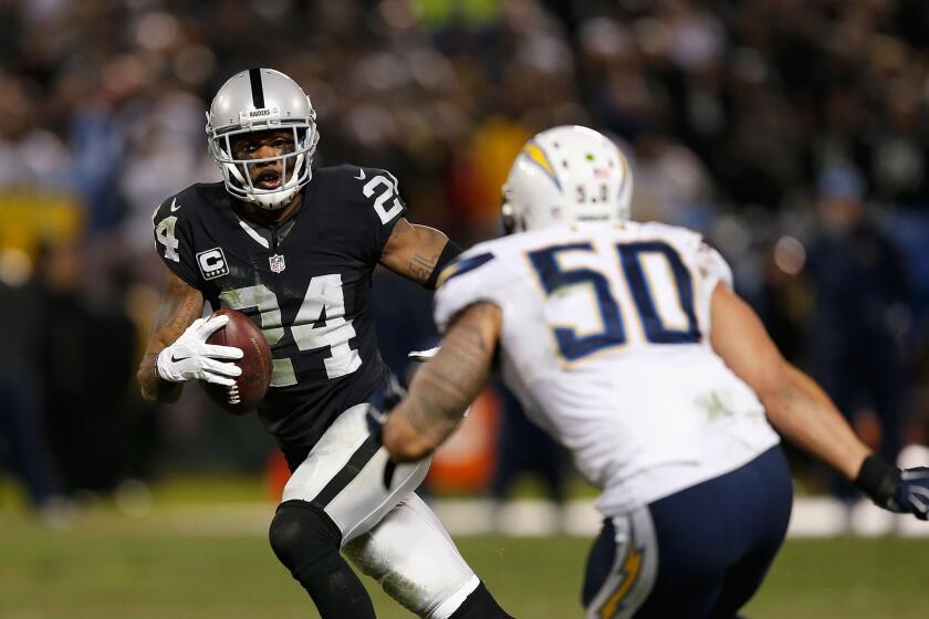 Raiders safety Charles Woodson looks to evade Chargers linebacker Manti Te'o in the fourth quarter.