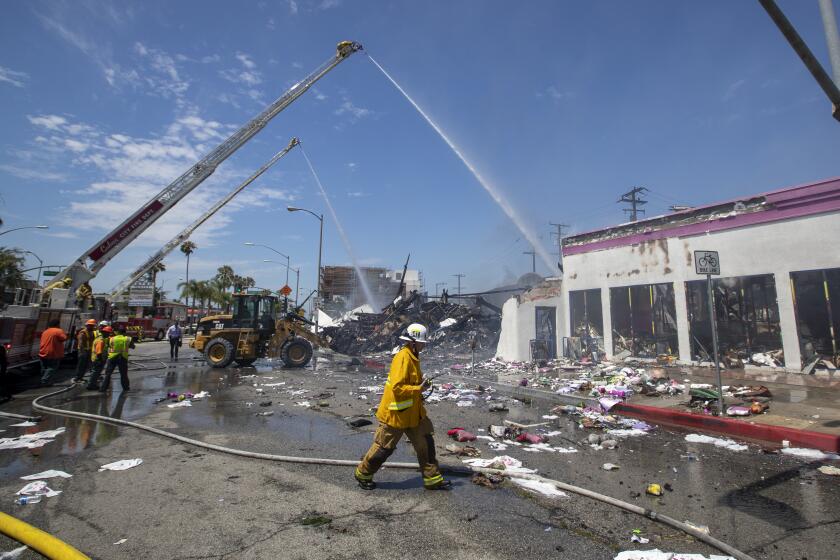 CULVER CITY, CALIF. -- MONDAY, JULY 22, 2019: Firefighters from Culver City and Los Angeles finish up battling a blaze in a 99 Cent store in Culver City at 1217 Washington Blvd. It was reported about 2:15 a.m. in the store and no injuries were reported and surrounding properties were not threatened. Photo taken in Culver City, Calif., on July 22, 2019. (Allen J. Schaben / Los Angeles Times)