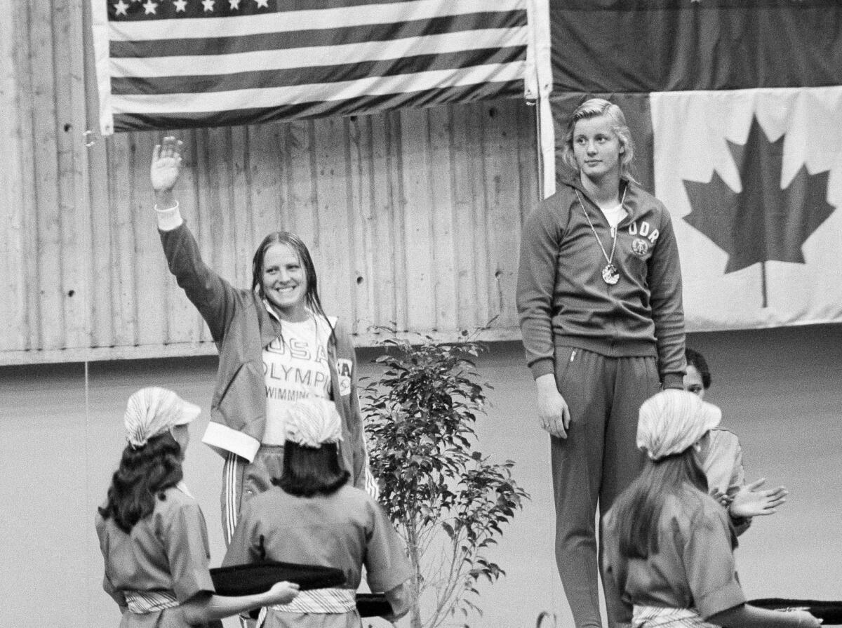 In this July 19, 1976 photo, East German swimmer Kornelia Ender, right, who was awarded the Olympic gold medal for the 200 meter freestyle event, stands on the podium, as her main opponent, silver medalist Shirley Babashoff of the U.S. acknowledges the crowd during the medal ceremony in Montreal, Canada.