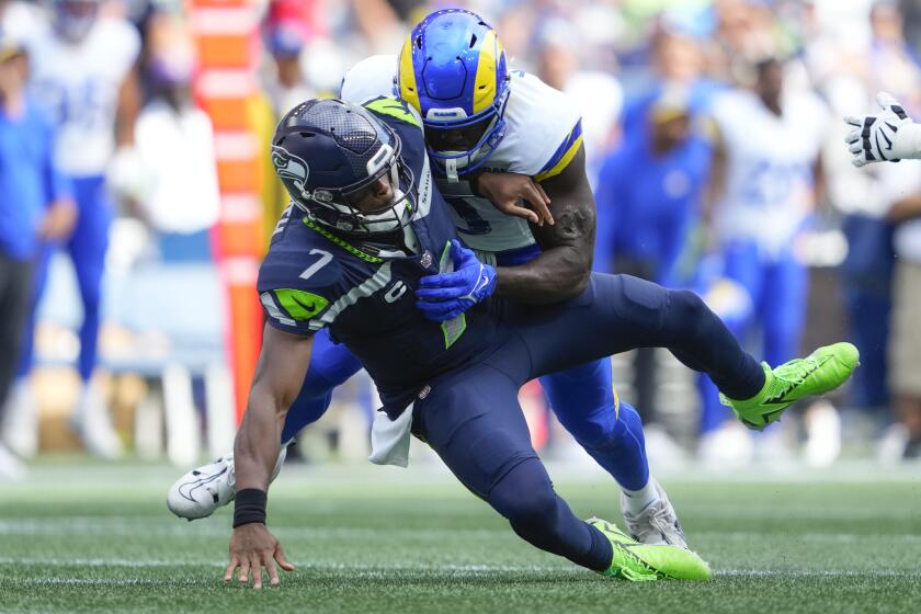 Seattle Seahawks quarterback Geno Smith (7) is sacked by Los Angeles Rams linebacker Byron Young (0) during the second half of an NFL football game, Sunday, Sept. 10, 2023, in Seattle. (AP Photo/Lindsey Wasson)