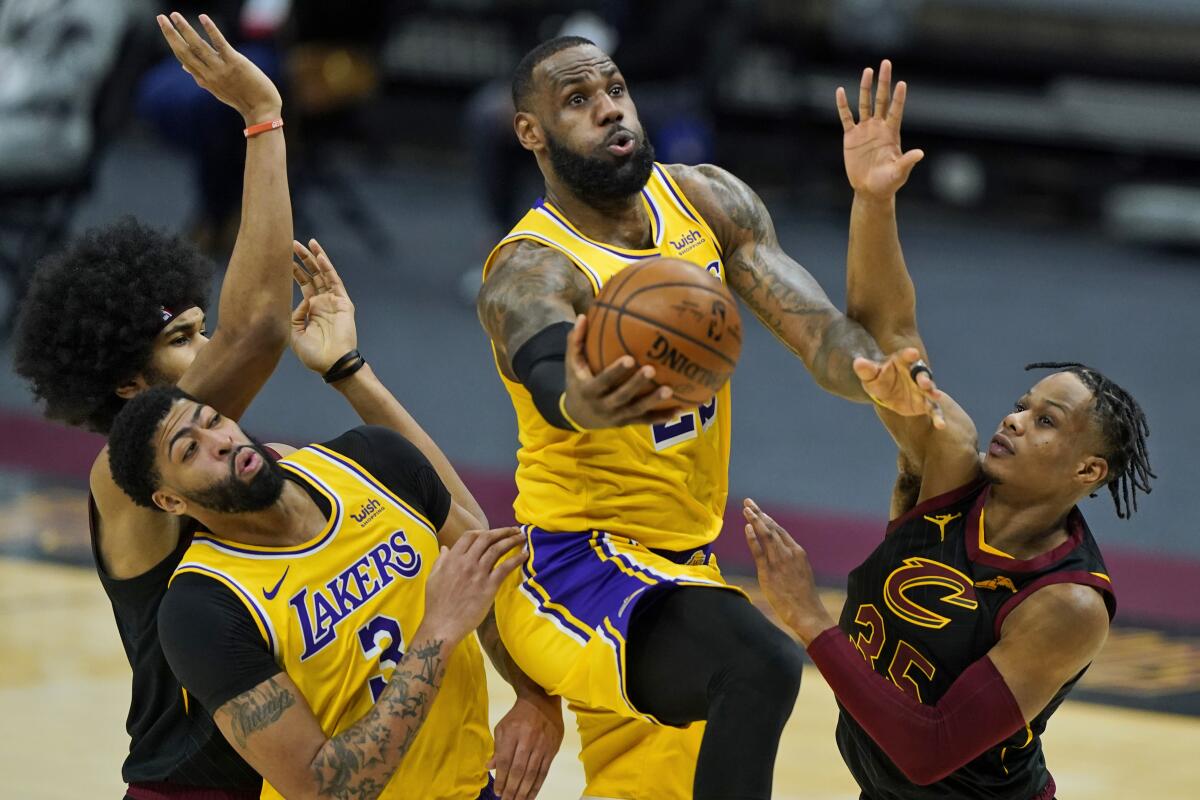 Lakers' LeBron James drives to the basket against Cleveland Cavaliers' Isaac Okoro.