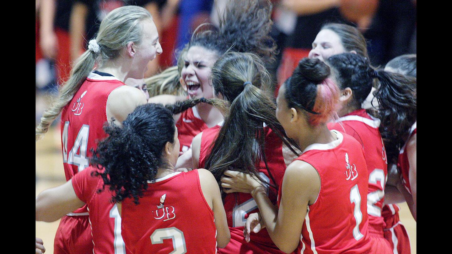 The Burroughs girls basketball ball team celebrates their rival win over Burbank. Burroughs wins the rival Pacific League girls basketball match up against Burbank in a nail biter to the end at Burbank High School on Thursday, January 22, 2016. Down by four in the final minute, Burroughs got to the free throw line three times to tie the game and again to go up by two to win the game.