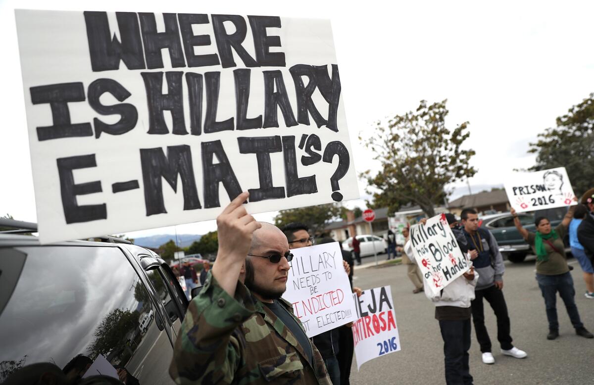 Protesters hold signs outside of a campaign rally for Democratic presidential candidate and former Secretary of State Hillary Clinton in Riverside in May.