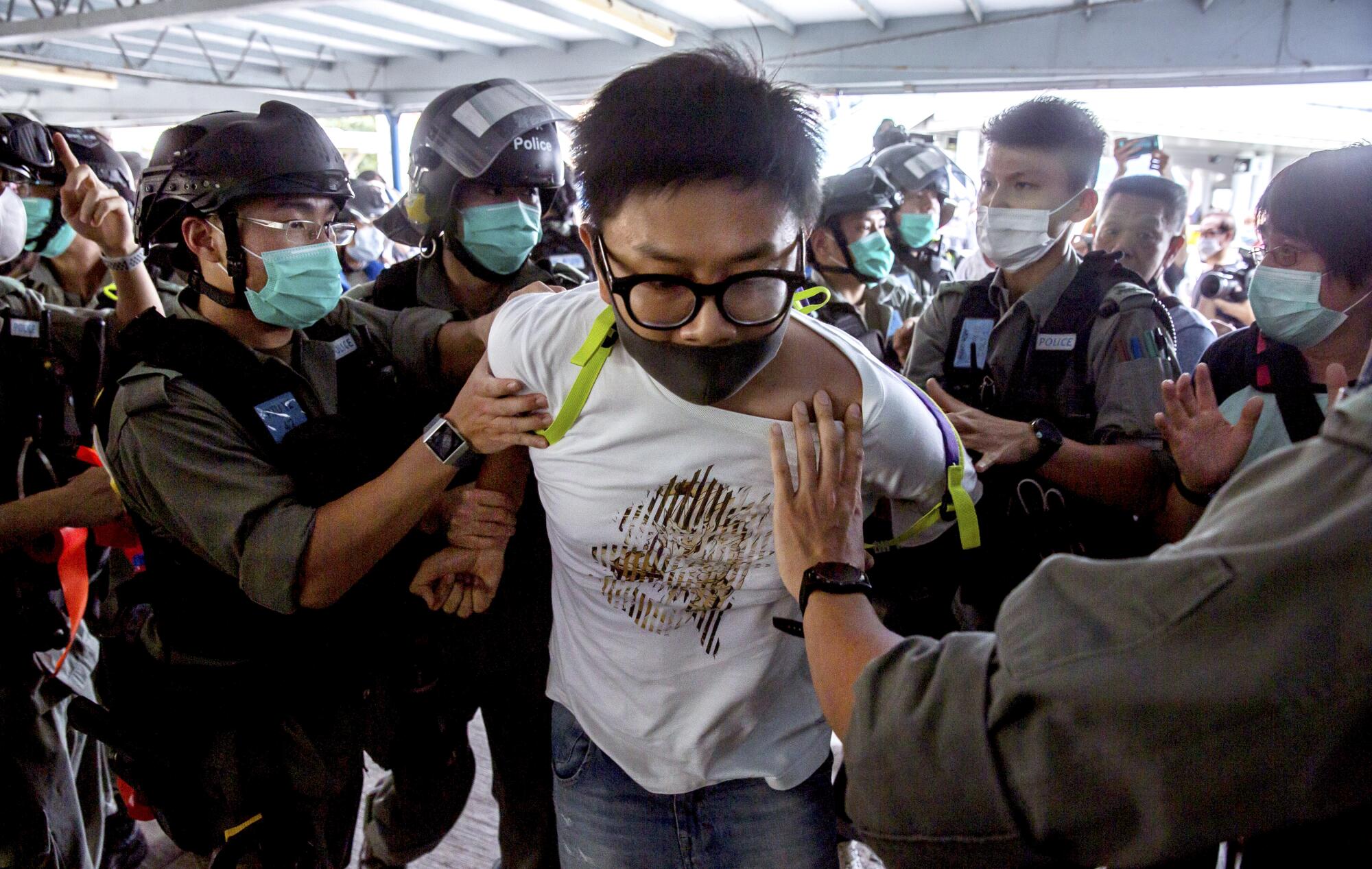 Police officers arrest a demonstrator in Hong Kong.