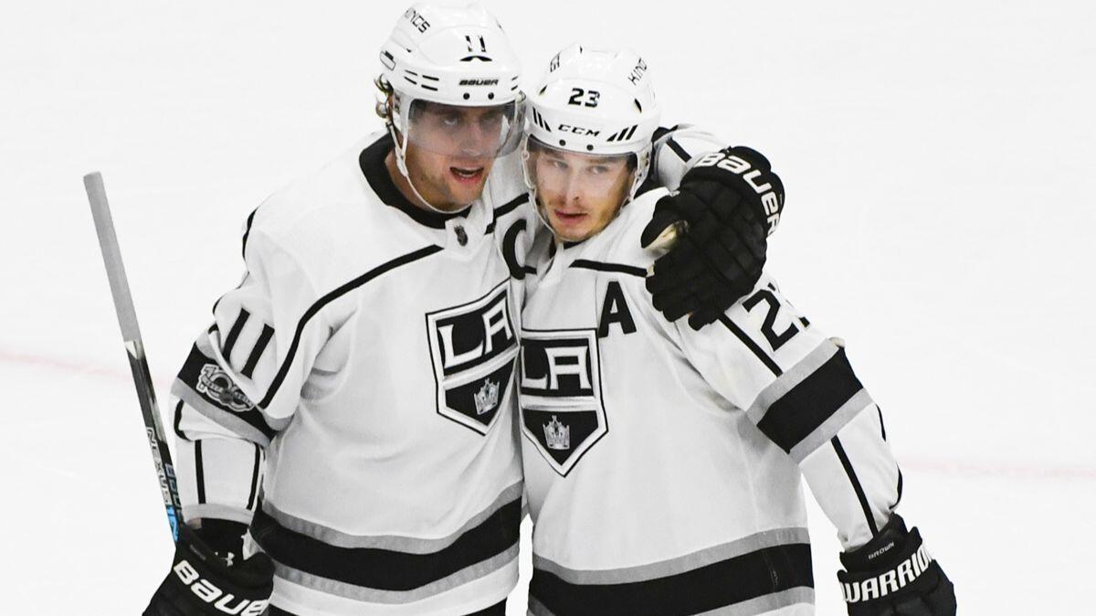 Kings center Anze Kopitar (11) hugs right wing Dustin Brown (23) after Brown scored an empty-net goal against the Chicago Blackhawks during the third period on Dec. 3, 2017.
