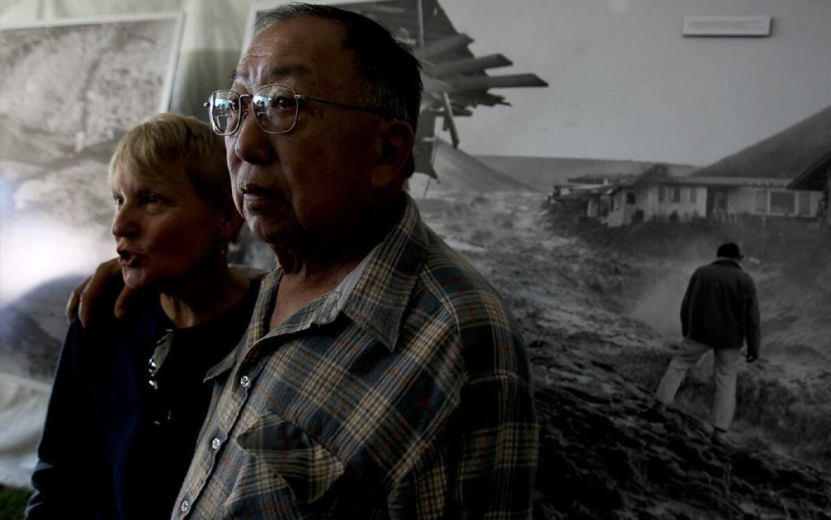 Ruth and Fred Kong look at large photo reproductions of the dam collapse in Baldwin Hills during Saturday's ceremony marking the 50th anniversary.