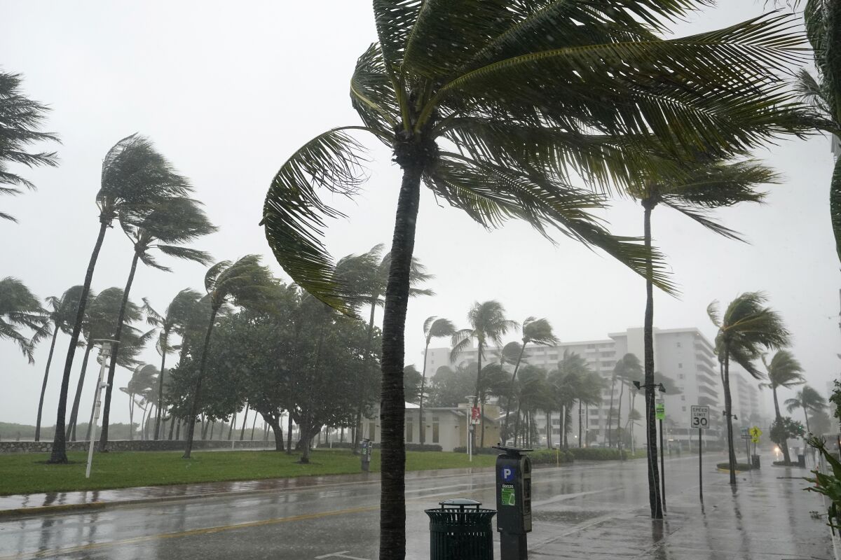 A normally bustling Ocean Drive is shown during a downpour, Sunday, Nov. 8, 2020, on Miami Beach, Florida's famed South Beach. A strengthening Tropical Storm Eta cut across Cuba on Sunday, and forecasters say it's likely to be a hurricane before hitting the Florida Keys Sunday night or Monday. (AP Photo/Wilfredo Lee)