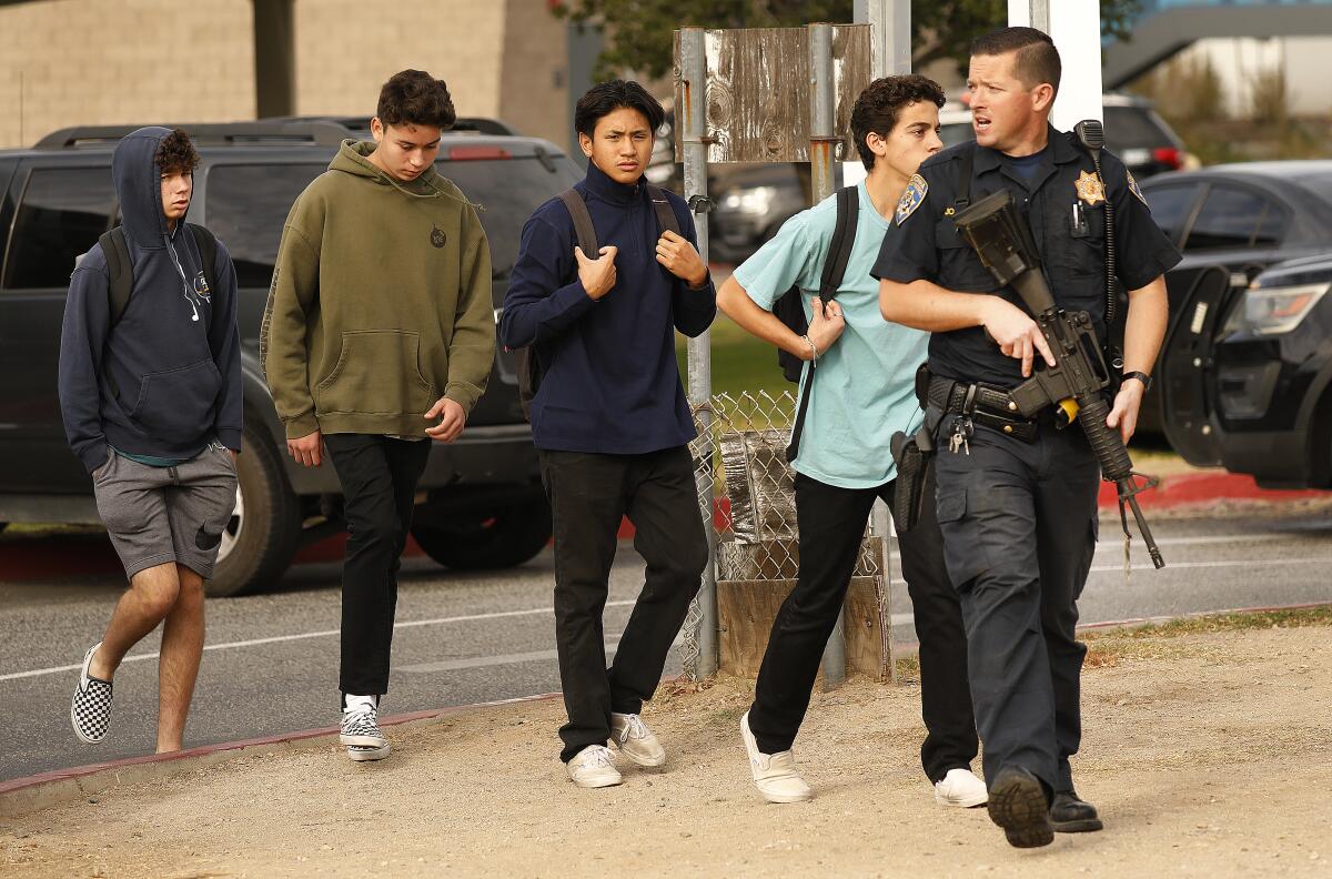 Students are escorted by police from the campus at Saugus High School after a gunman opened fire early Thursday.