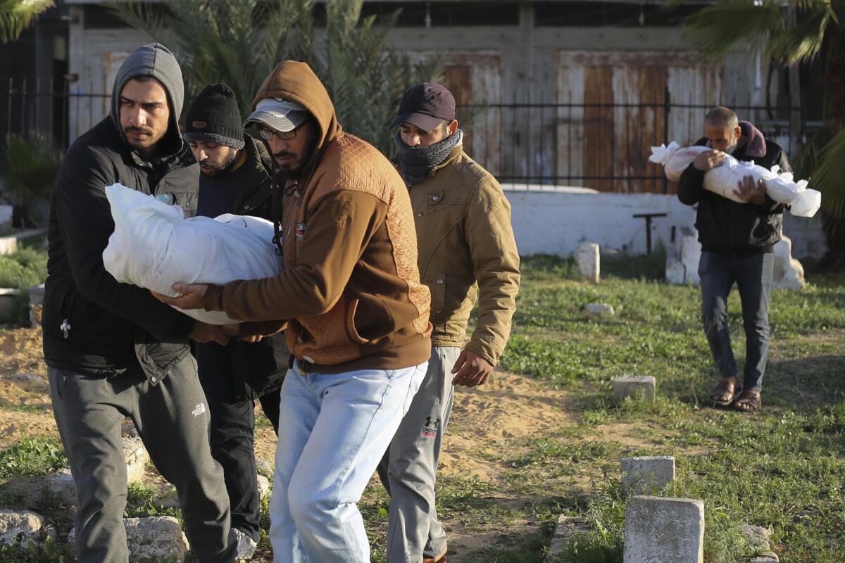 Palestinos cargan los cuerpos de los miembros de la familia Dhair, que murieron en un bombardeo israelí