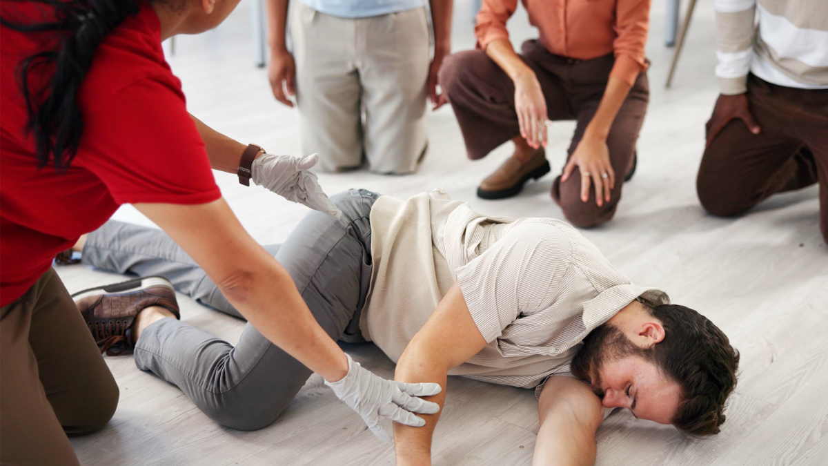 People, demonstration and class for first aid, teaching or recovery position to prevent aspiration.