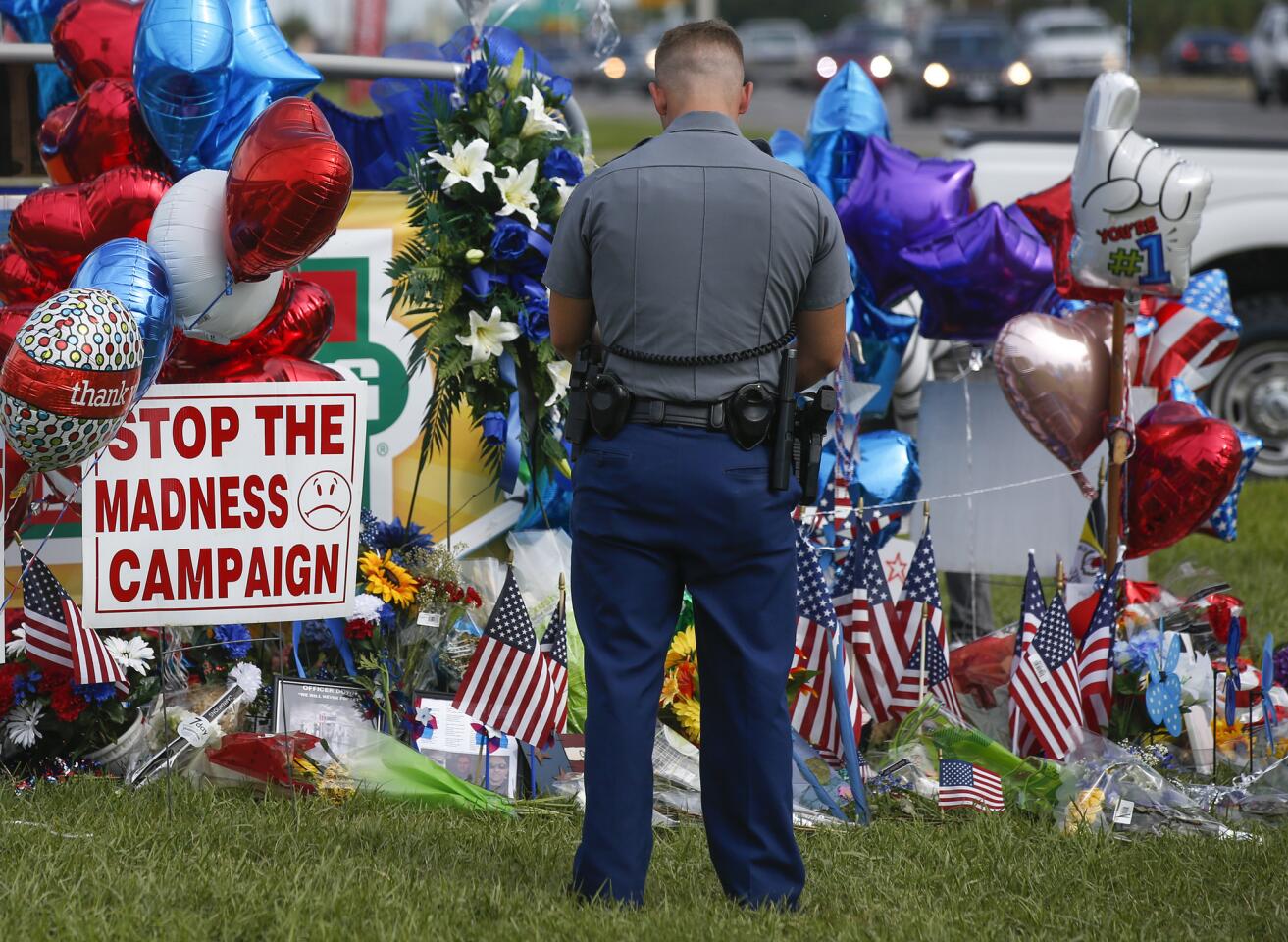 Louisiana police officer PJ Freeman stops to pay his respects at a roadside memorial for the three officers slain in Baton Rouge.