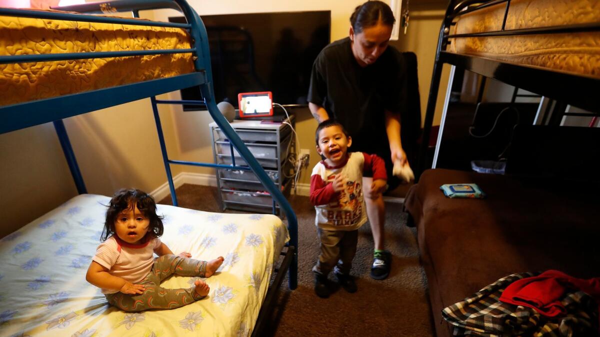 Annabel Vasquez, 35, her son Andrew Flores, 3, and daughter Aliah Flores, 1, relax in a South Los Angeles home. The five-bedroom house is part of the Shelter Crisis Housing program, which takes Hopics clients.