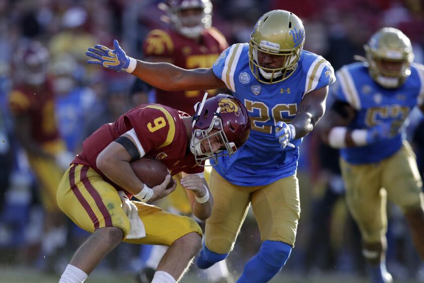 Southern California quarterback Kedon Slovis (9) is tackled by UCLA linebacker Leni Toailoa.