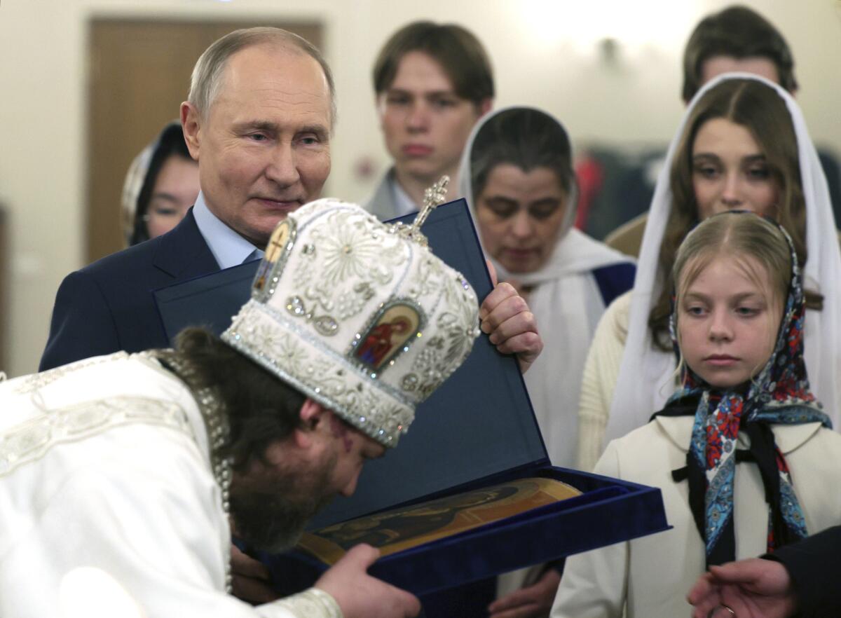 Vladimir Putin and others attend an Orthodox Christmas ceremony.