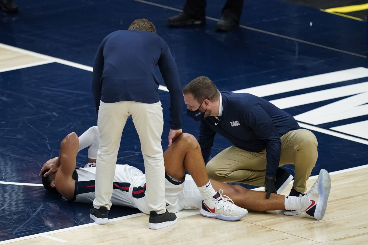 Gonzaga coach Mark Few stands over Jalen Suggs (1) as he is examined during the first half of the team's NCAA college basketball game against West Virginia, Wednesday, Dec. 2, 2020, in Indianapolis. (AP Photo/Darron Cummings)