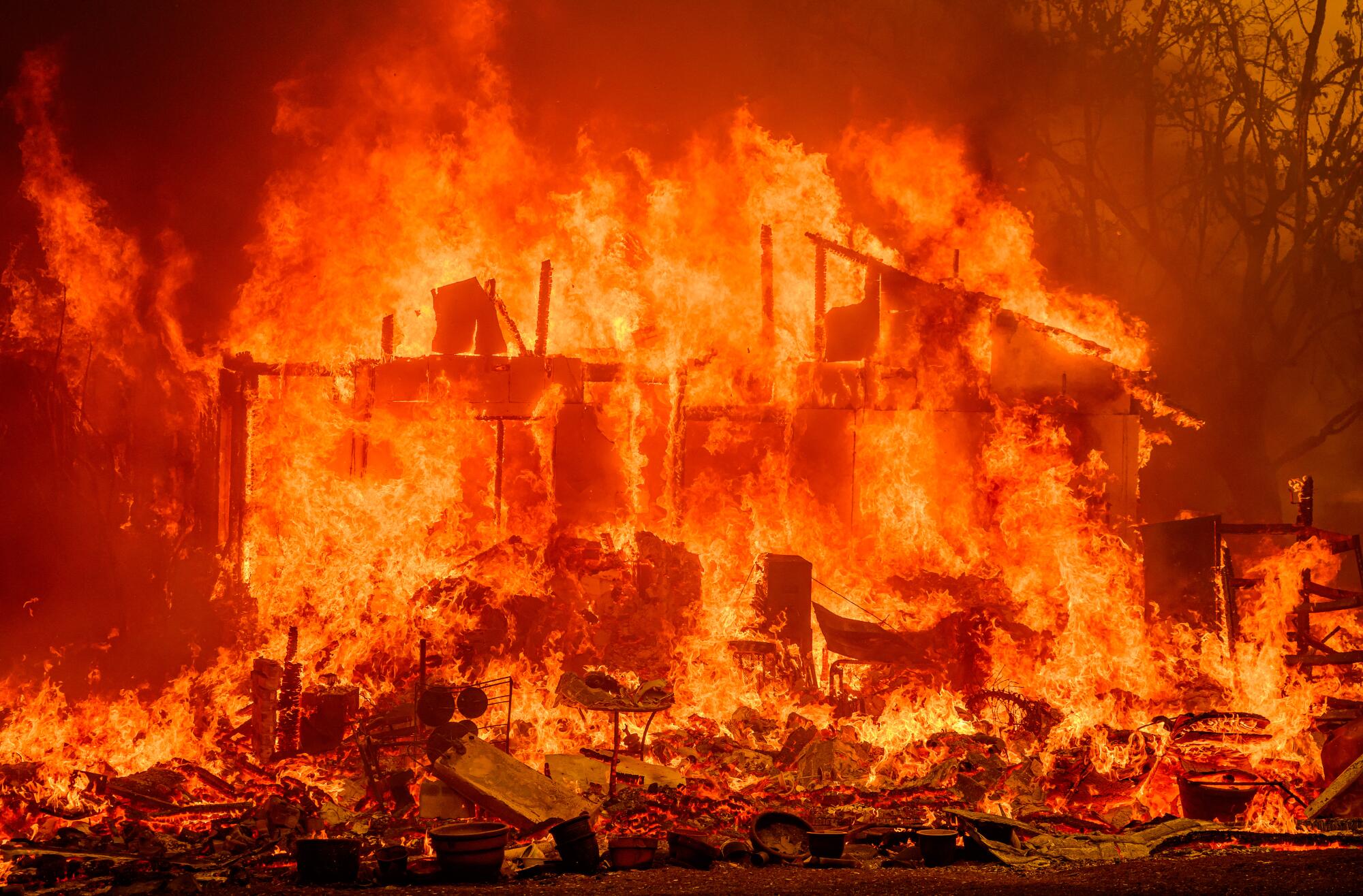 Flames engulf a home during the Thompson fire in Oroville.