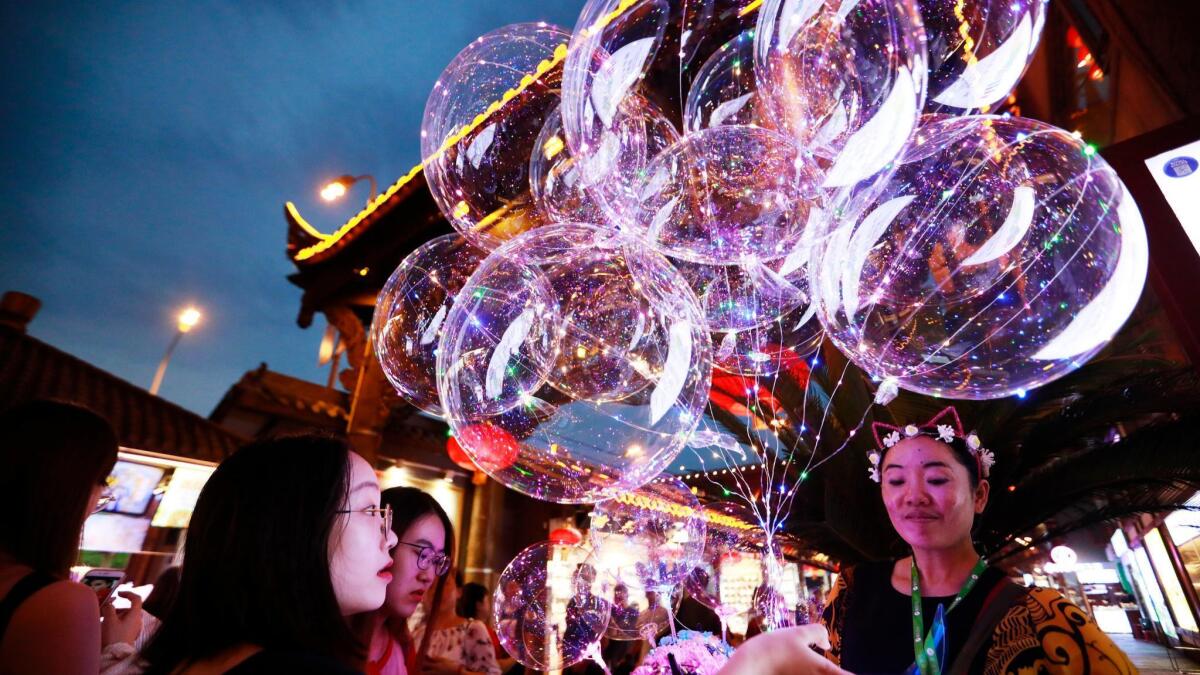 A woman sells balloons in Hong Ya Dong, or Red Cliff Cave, in Chongqing, China. Chongqing, in the southwest, is one of China's top tourism cities.