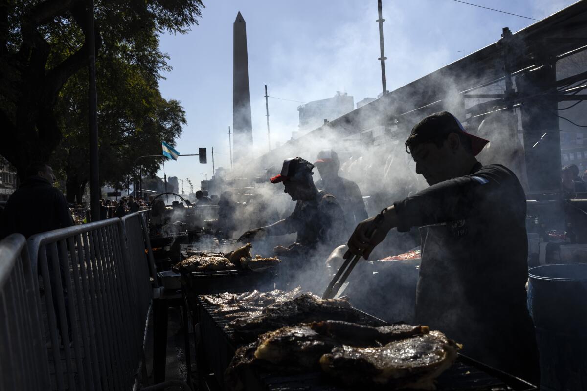 Trabajadores asan carne en un puesto durante un campeonato de parrilleros el domingo 14 de agosto de 2022
