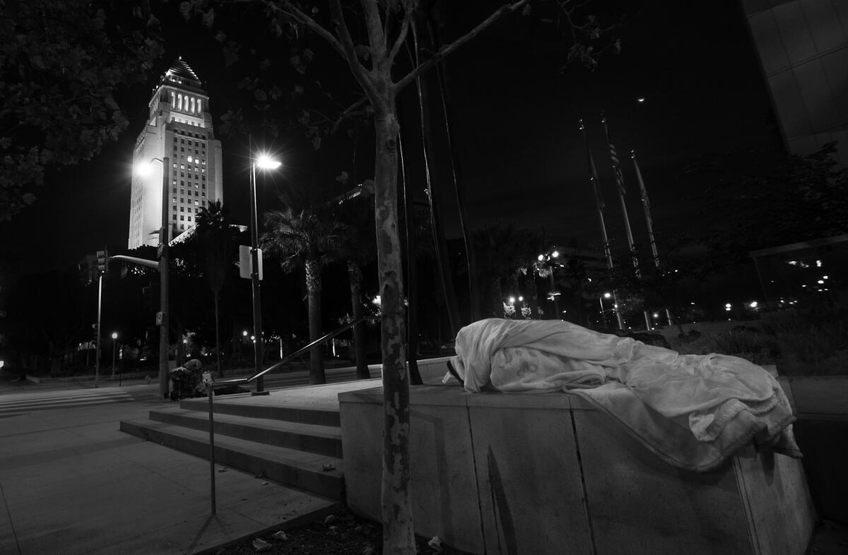 A person sleeps at 1st and Spring streets, across from Los Angeles City Hall.