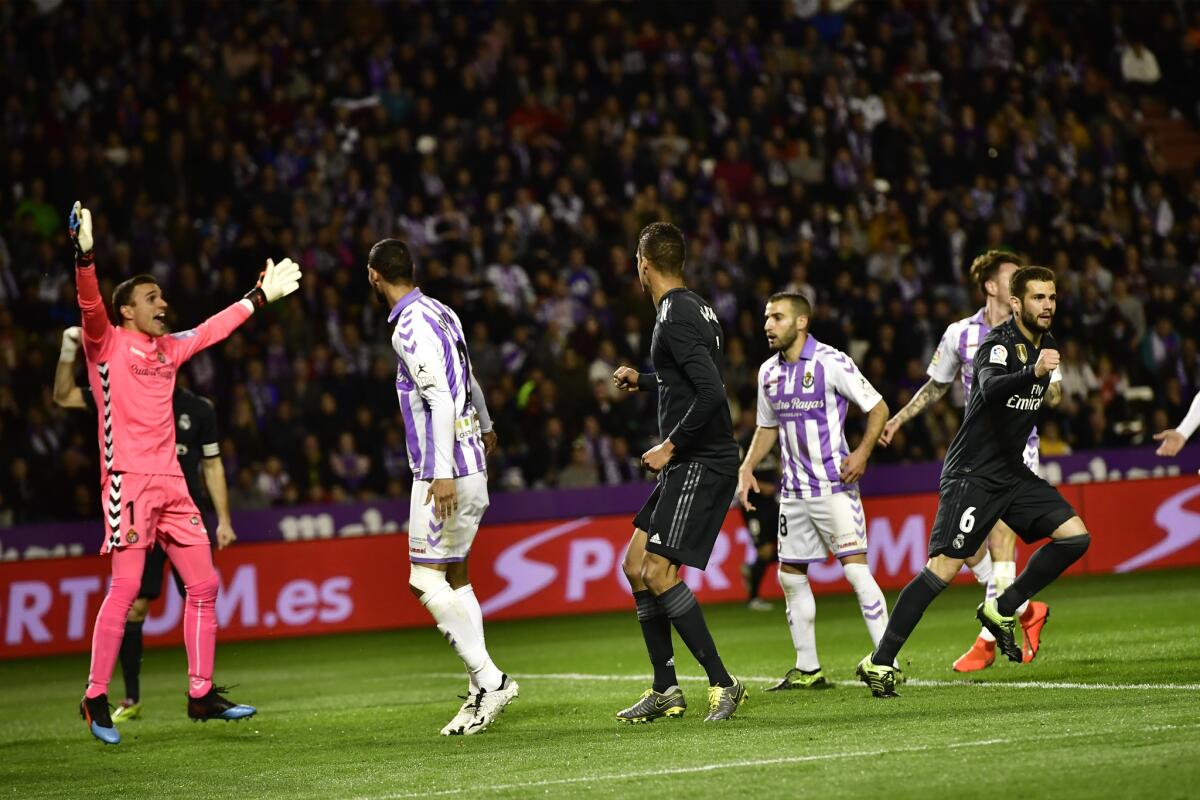 Real Madrid's Nacho Fernandez, right, celebrates his goal as Real Valladolid's goalkeeper Jordi Masip protests during the Spanish La Liga soccer match between Real Madrid and Valladoid FC at Jose Zorrila New stadium in Valladolid, northern Spain, Sunday, March 10, 2019.