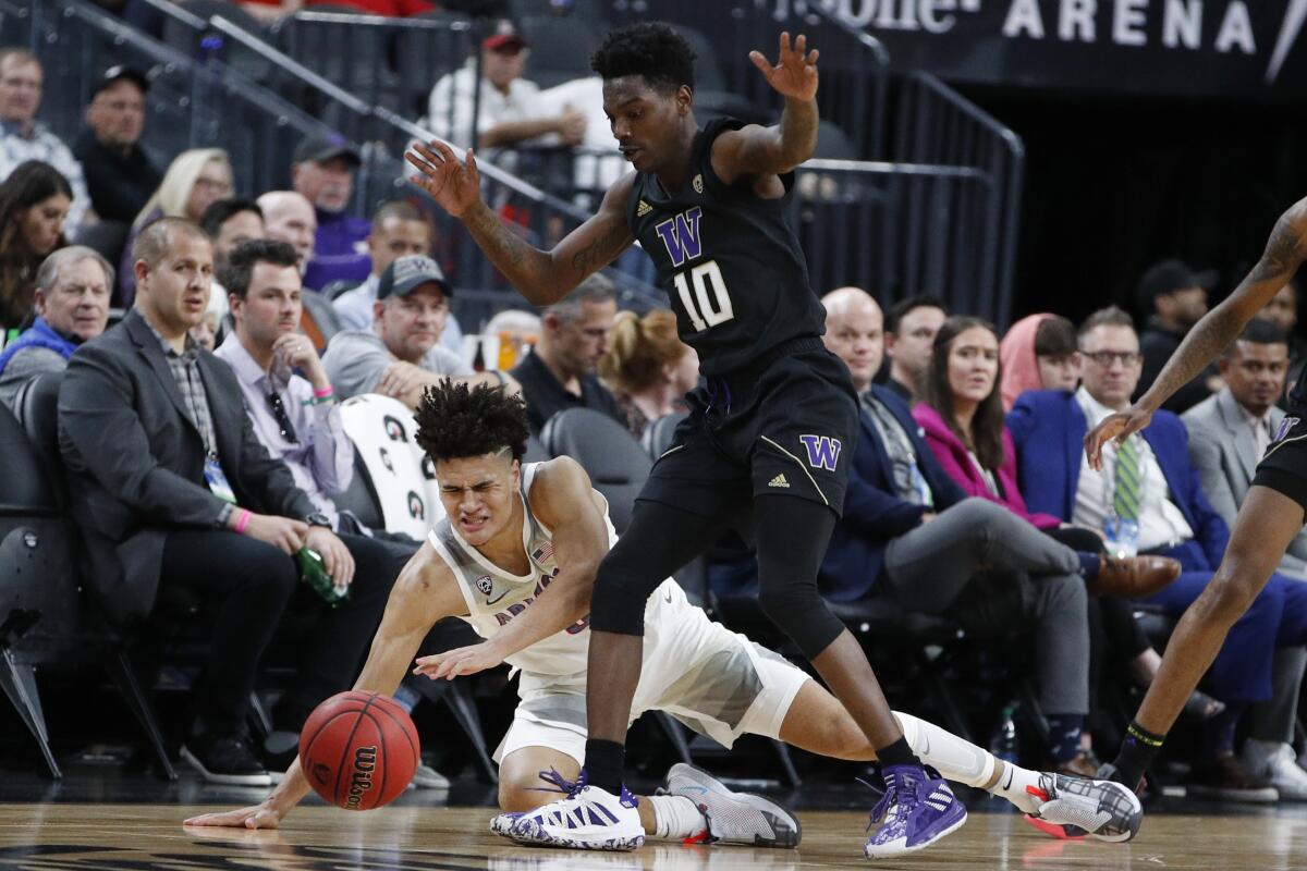 Arizona's Josh Green, left, and Washington's Elijah Hardy (10) battle for the ball during the first half of the Pac-12 men's tournament on Wednesday in Las Vegas.