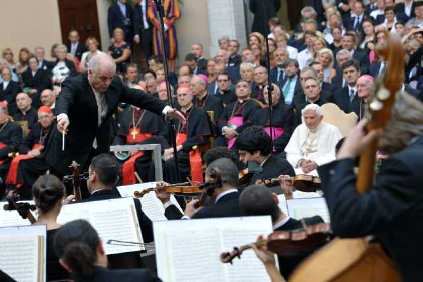 Daniel Barenboim conducts members of the West-Eastern Divan Orchestra near Rome as Pope Benedict XVI, seated at right, listens.