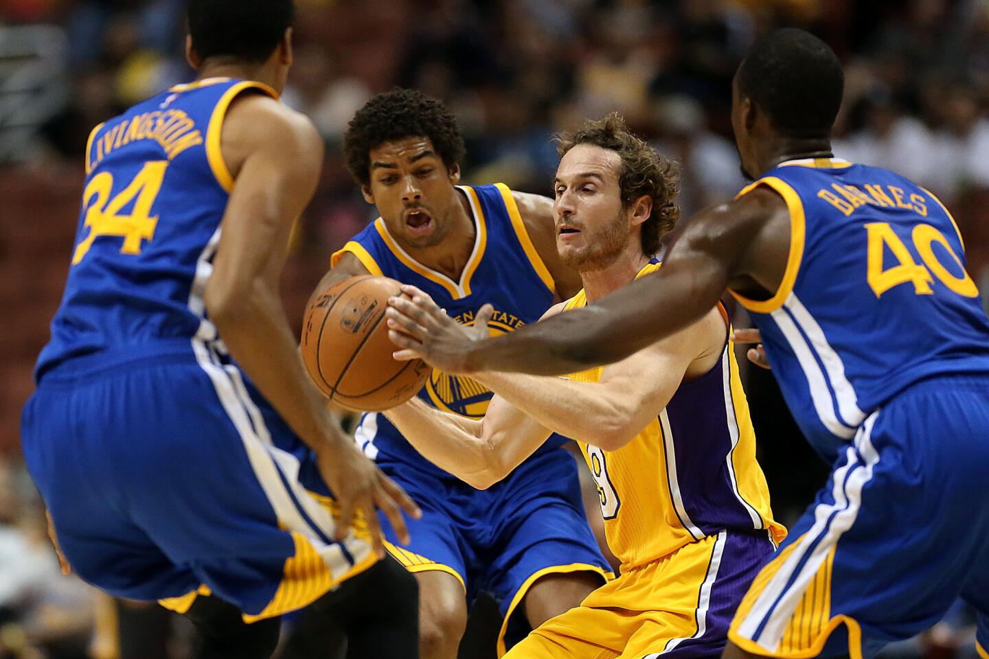 Lakers guard Marcelo Huertas looks to pass as three Warriors defenders converge on him in a preseason game at Honda Center on Thursday night.