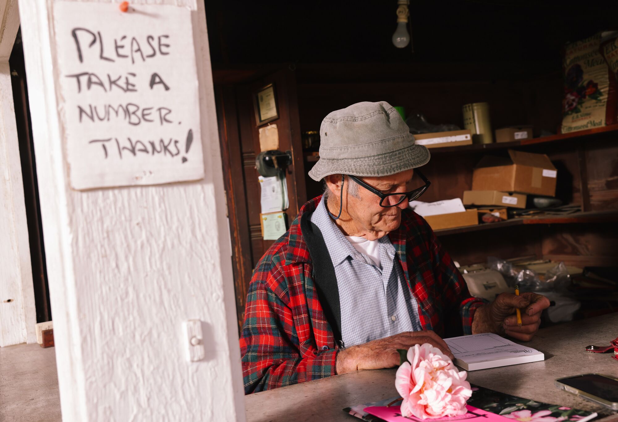 Tom Nuccio writes out a receipt by hand.