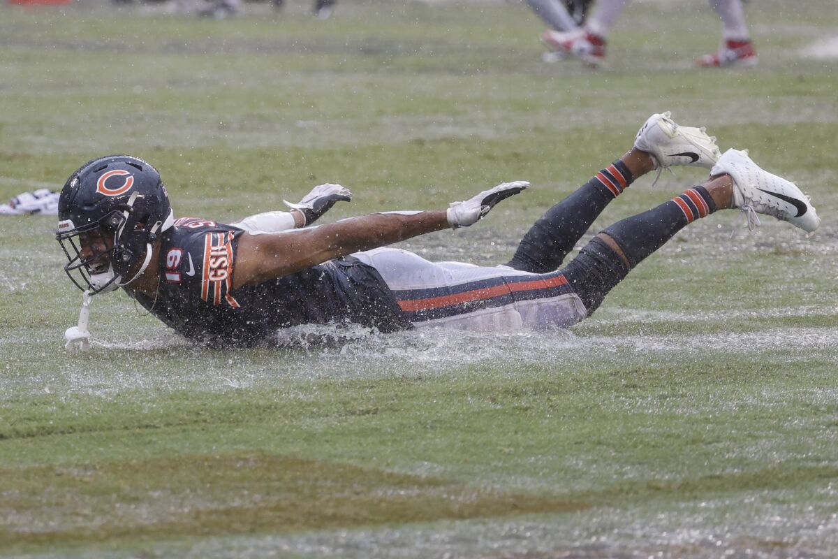 Equanimeous St. Brown (19) celebrates the Chicago Bears win against the San Francisco 49ers with a puddle slide.