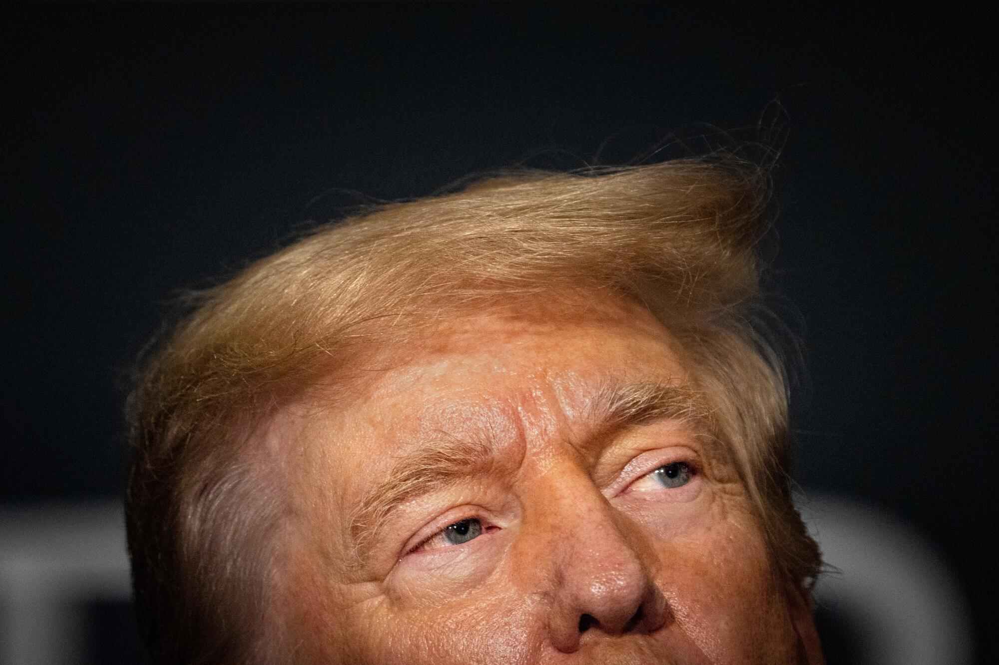 A close-up of Donald Trump's face, framed nose and up.