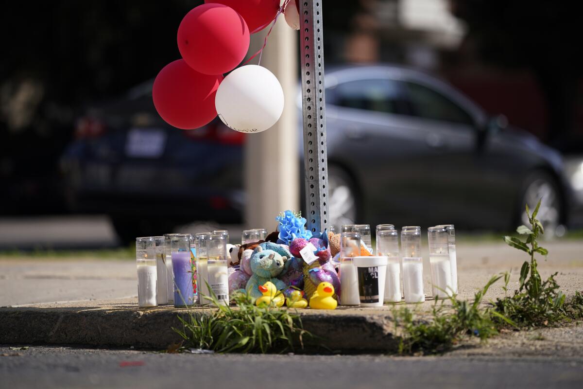 Balloons, candles and mementos for a mass shooting victim on a sidewalk in Philadelphia.