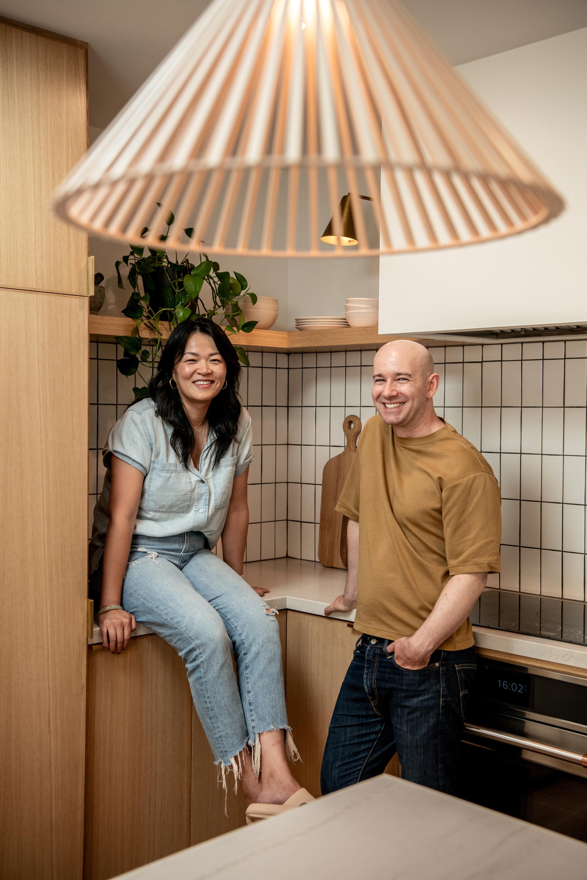 Jing Guo and Gabriel Taylor Russ smile inside their kitchen.