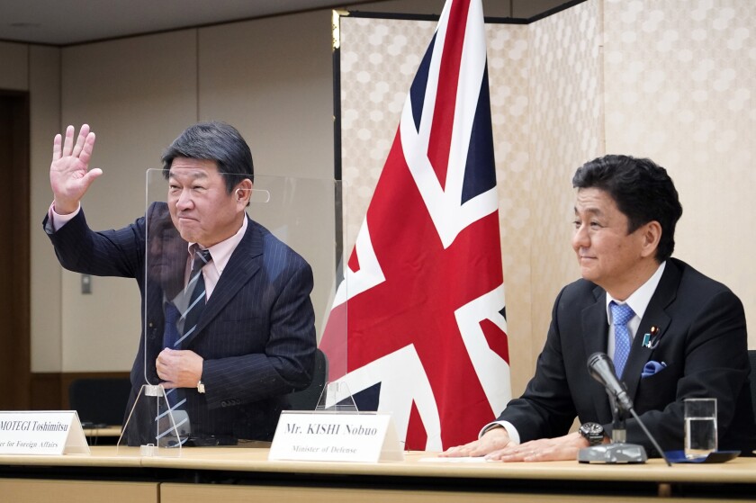 Japan's Foreign Minister Toshimitsu Motegi, left, and Defense Minister Nobuo Kishi attend a video conference with British Foreign Secretary Dominic Raab and Defense Minister Ben Wallace on screen, not seen, at the Foreign Ministry in Tokyo, Feb. 3 2021. Both parties held their 4th Japan-UK Foreign and Defense Ministerial Meeting '2+2' to strengthen their cooperation. (Franck Robichon/Pool via AP)