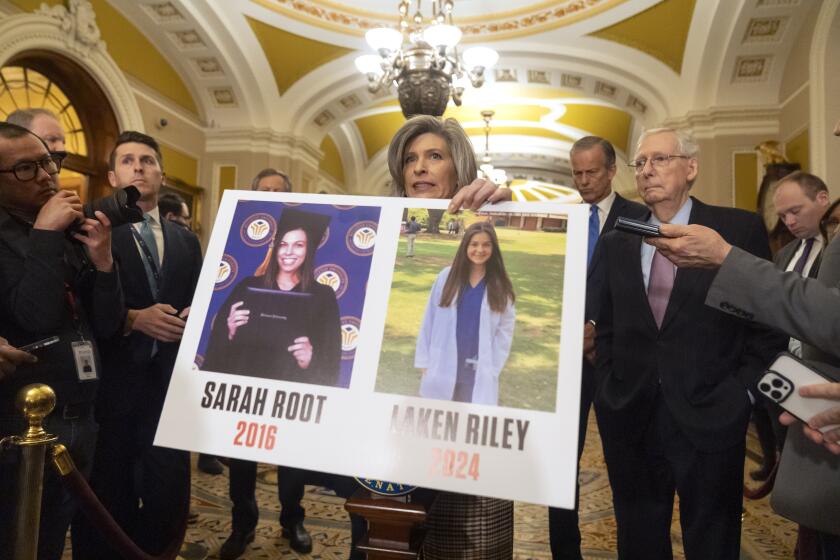 ARCHIVO - La senadora Joni Ernst, representante de Iowa, sostiene un cartel con fotos de las víctimas de asesinato Sarah Root y Laken Riley mientras habla en Capitol Hill, el 27 de febrero de 2024 en Washington. (AP Foto/Mark Schiefelbein, Archivo)