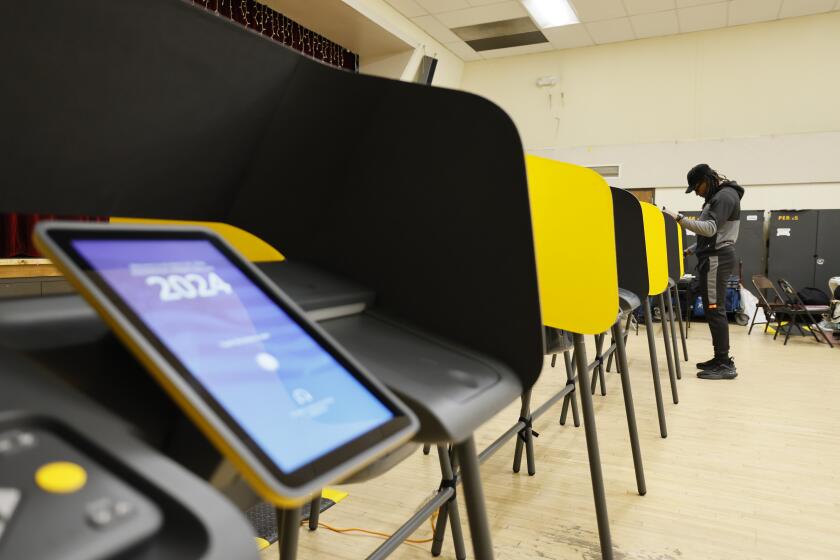 Boyle Heights, CA - March 05: Brandon Ellerby, right, of Los Angeles, casts his ballot during Super Tuesday primary election at the Boyle Heights Senior Center in Boyle Heights Tuesday, March 5, 2024. (Allen J. Schaben / Los Angeles Times)