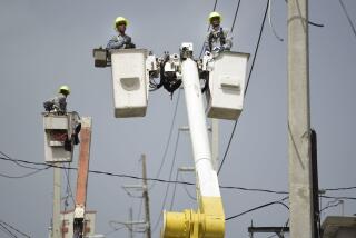 FILE - Puerto Rico Electric Power Authority workers repair distribution lines damaged by Hurricane Maria in the Cantera community of San Juan, Puerto Rico, Oct. 19, 2017. The private operator of Puerto Rico’s power grid confirmed Monday, June 24, 2024, the deferral of $65 million worth of maintenance and improvement projects in the U.S. territory, with some repairs postponed for at least a year because of budget constraints. (AP Photo/Carlos Giusti, File)