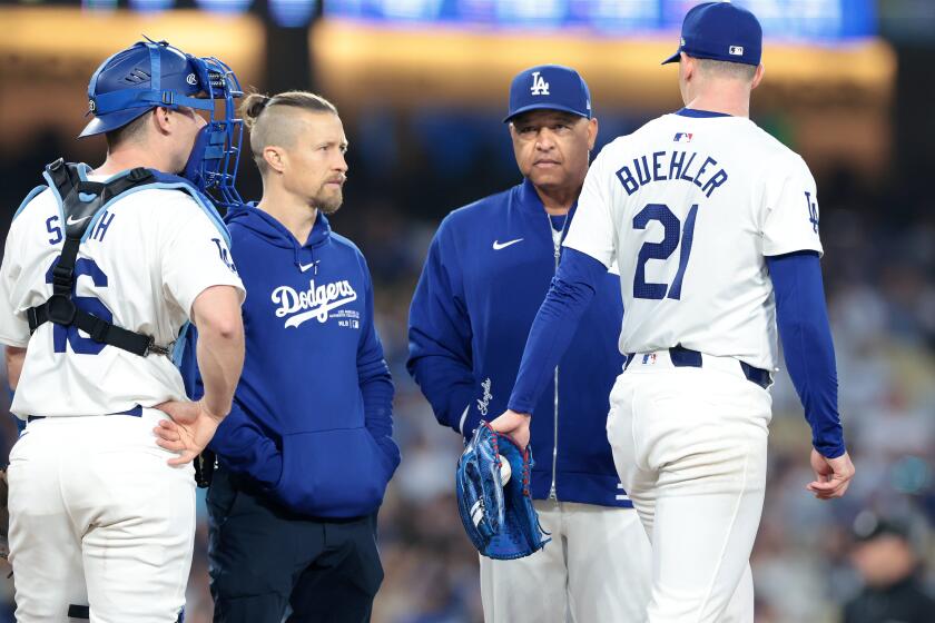 LOS ANGELES CALIFORNIA CALIFORNIA-A Dodgers trainer and manager Dave Roberts check on pitcher Walker Buehler in the fourth inning at Dodgers Stadium Wednesday. (Wally Skalij/Los Angeles Times)