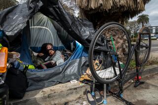 BEVERLY HILLS, CA - MAY 11: Houseless James Boss, 30, left, and his friend who declined give her name, waits in their tent to get housing under Inside Safe program, along 400 S. San Vicente Boulevard, Beverly Hills, CA. (Irfan Khan / Los Angeles Times)