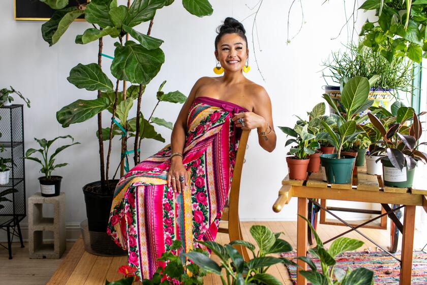 FULLERTON, CA - JULY 20: Jennifer Aragon, owner of the Green Place plant shop, sits for a portrait in the window of her plant shop surrounded by a wide array of beautiful plants on Wednesday, July 20, 2022 in Fullerton, CA. (Jason Armond / Los Angeles Times)