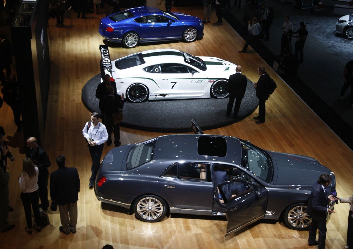 The Bentley exhibit displays the the 2013 Bentley Mulsanne (gray), the Bentley Continental GT3 concept race car (white) and the 2013 Bentley GT Speed.