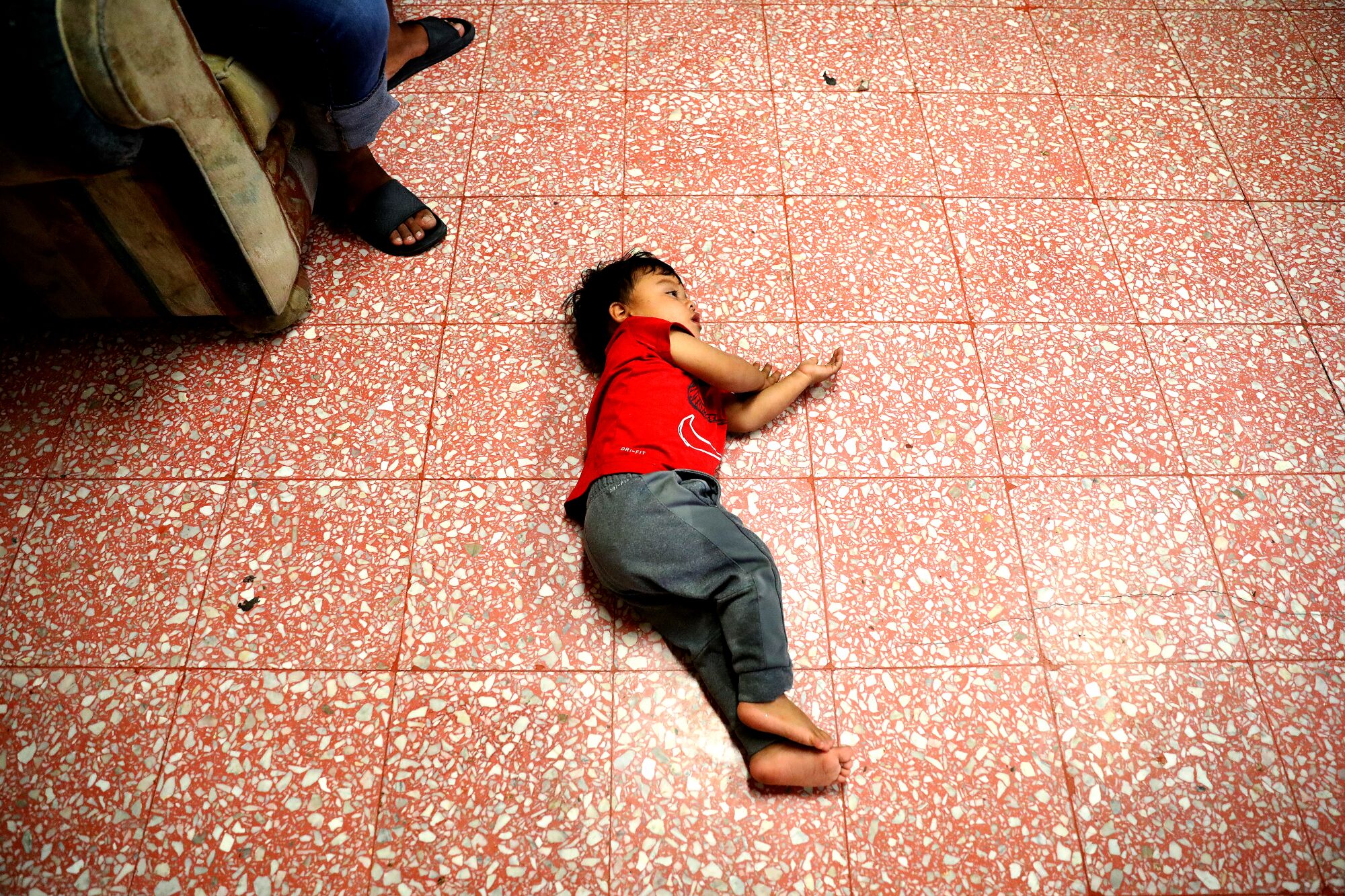 A boy lies on the floor at a shelter in Mexicali, Mexico.
