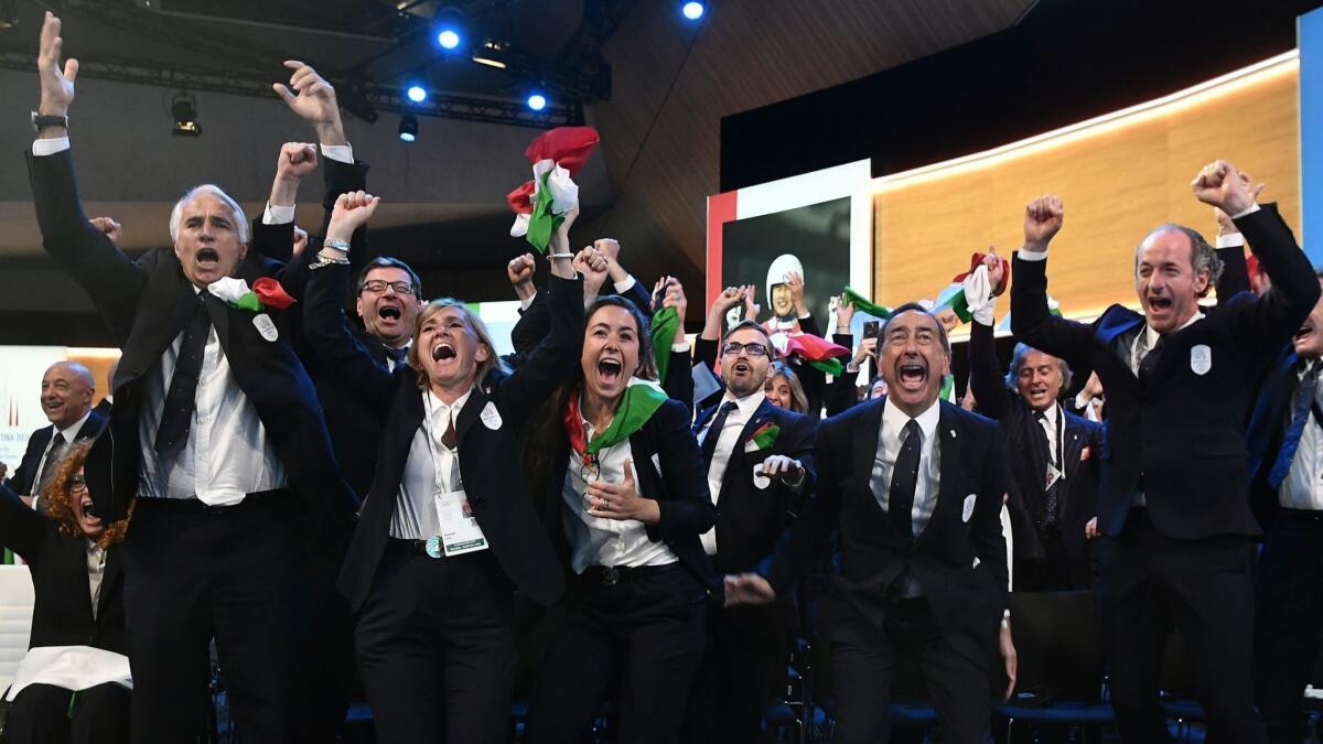 Members of the delegation from Milan/Cortina d'Ampezzo react Monday in Lausanne, Switzerland, after the Italian cities were announced as the host of the 2026 Winter Olympics.
