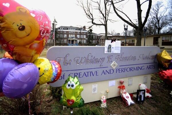 A tribute of flowers and balloons to Houston is seen at the Whitney E. Houston Academy in East Orange, N.J.