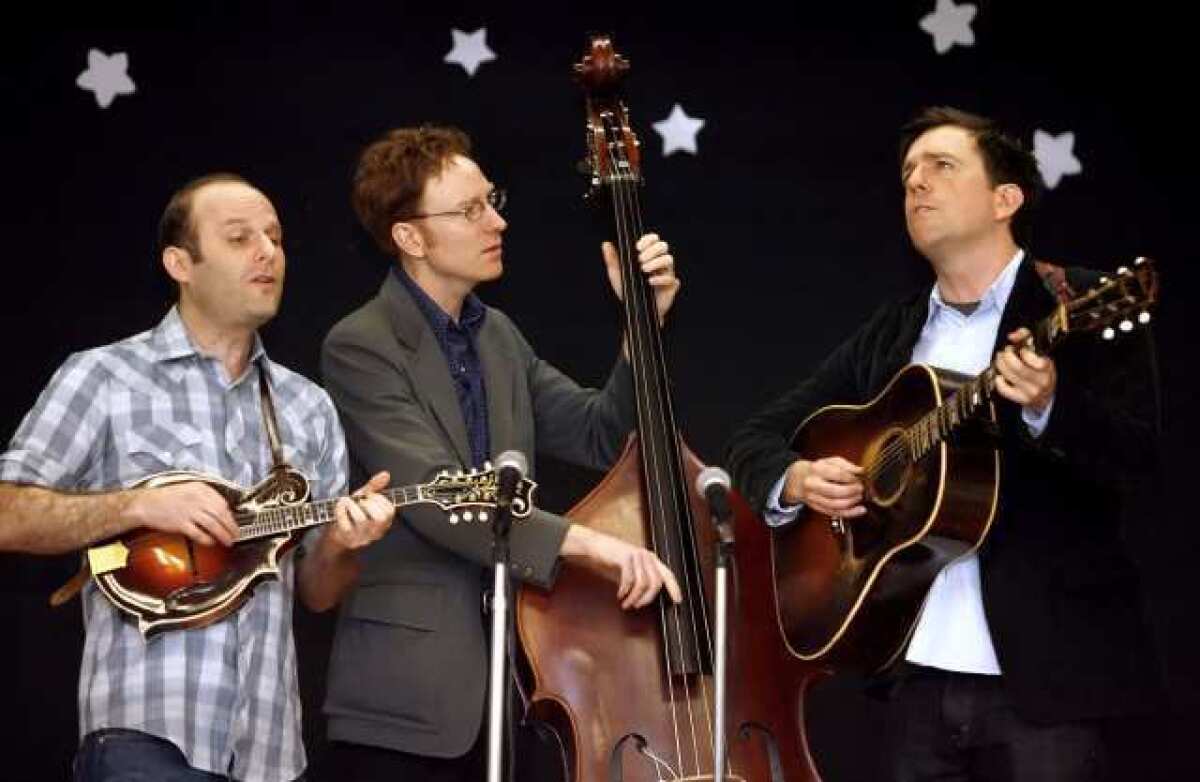 Actor and musician Ed Helms, right, sings along with his group the Lonesome Trio (Jacob Tilove, left, and Ian Riggs, center) during a visit to Providencia Elementary School in Burbank.