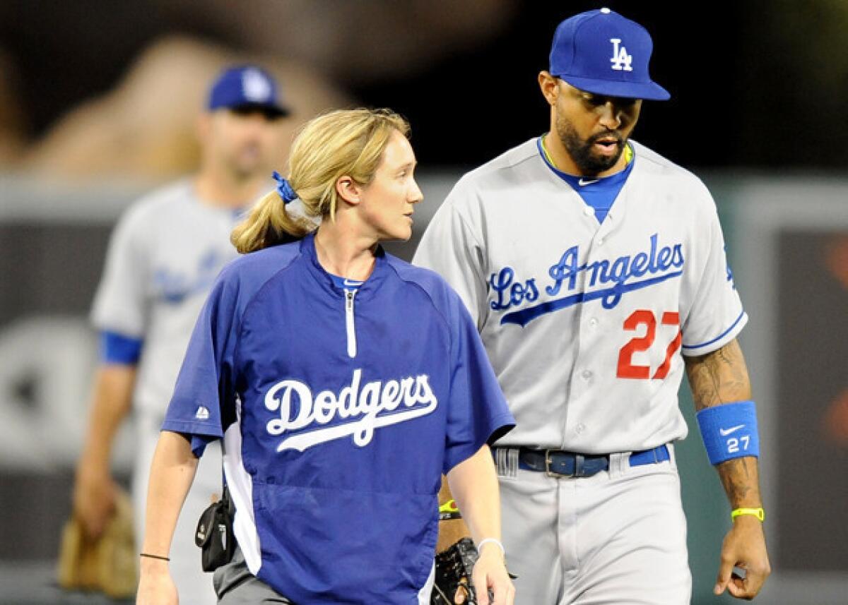 Dodgers' Matt Kemp comes out of the game with Dodgers assistant trainer Nancy Patterson in the seventh inning against the Angels.