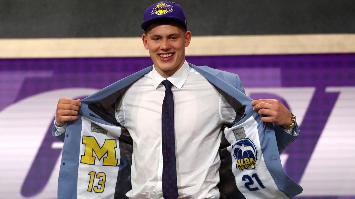 Moe Wagner shows off the interior of his suit jacket, featuring emblems of his college and German club team.