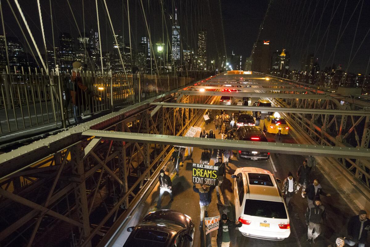 Demonstrators march over the Brooklyn Bridge in New York on Saturday during the Justice for All protest. Police announced Thursday that they have arrested one protester involved in an altercation that left a police officer with a broken nose.